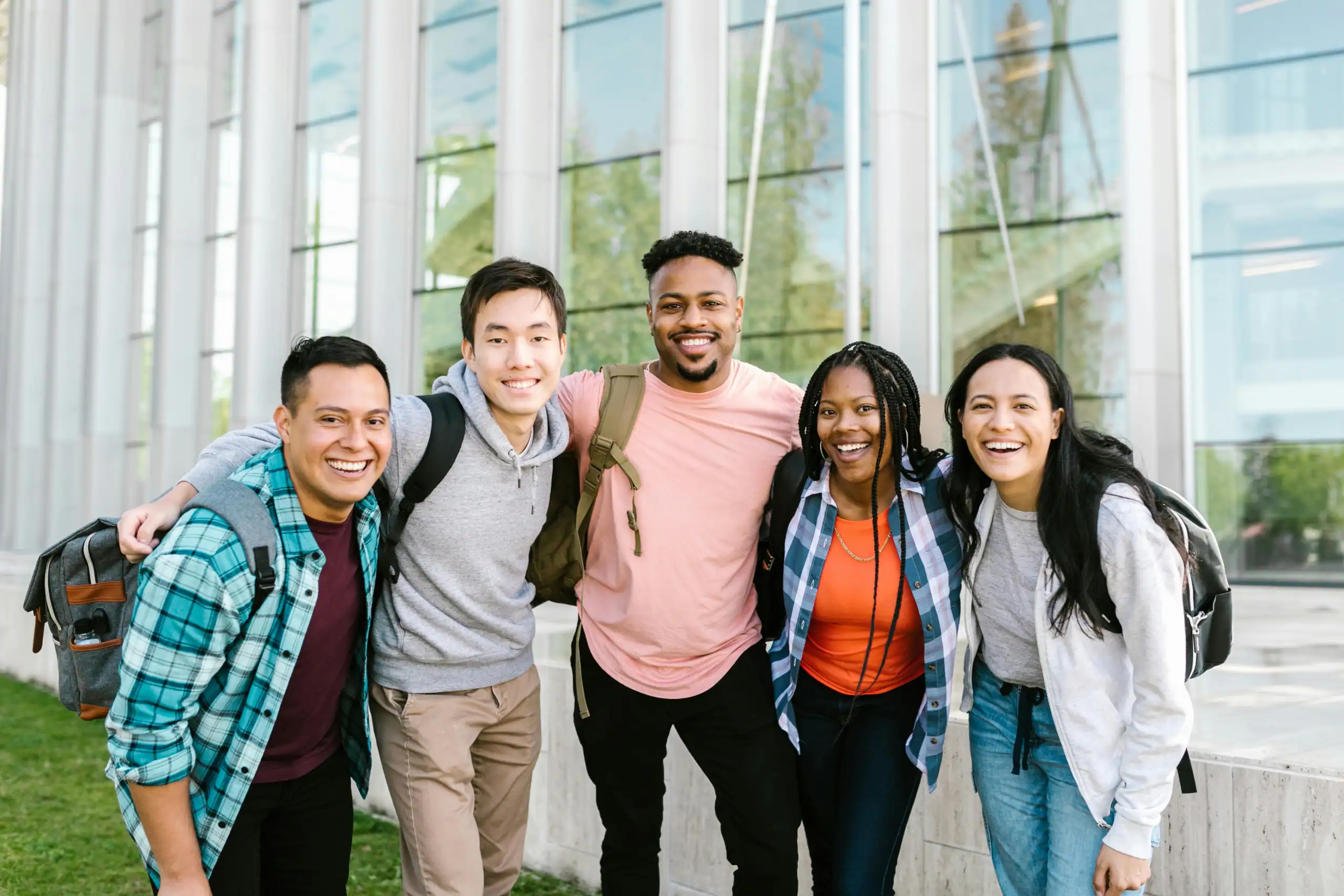 Diverse group of university students smiling and posing together on campus.