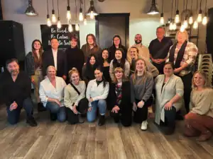 Large group photo of R.I.C. graduate interns and supervisors at year-end celebration