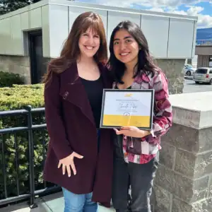 Chanelle Febre receiving her Graduate Student Internship Award with R.I.C. supervisor outdoors in Kelowna.