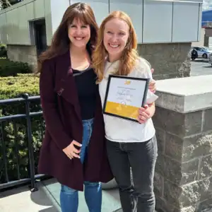 Graduate intern Josephine Ruoss receiving her internship award with R.I.C. supervisor outdoors.
