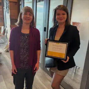 Graduate intern Sierra Garabed receiving her Graduate Student Internship Award with R.I.C. supervisor indoors.