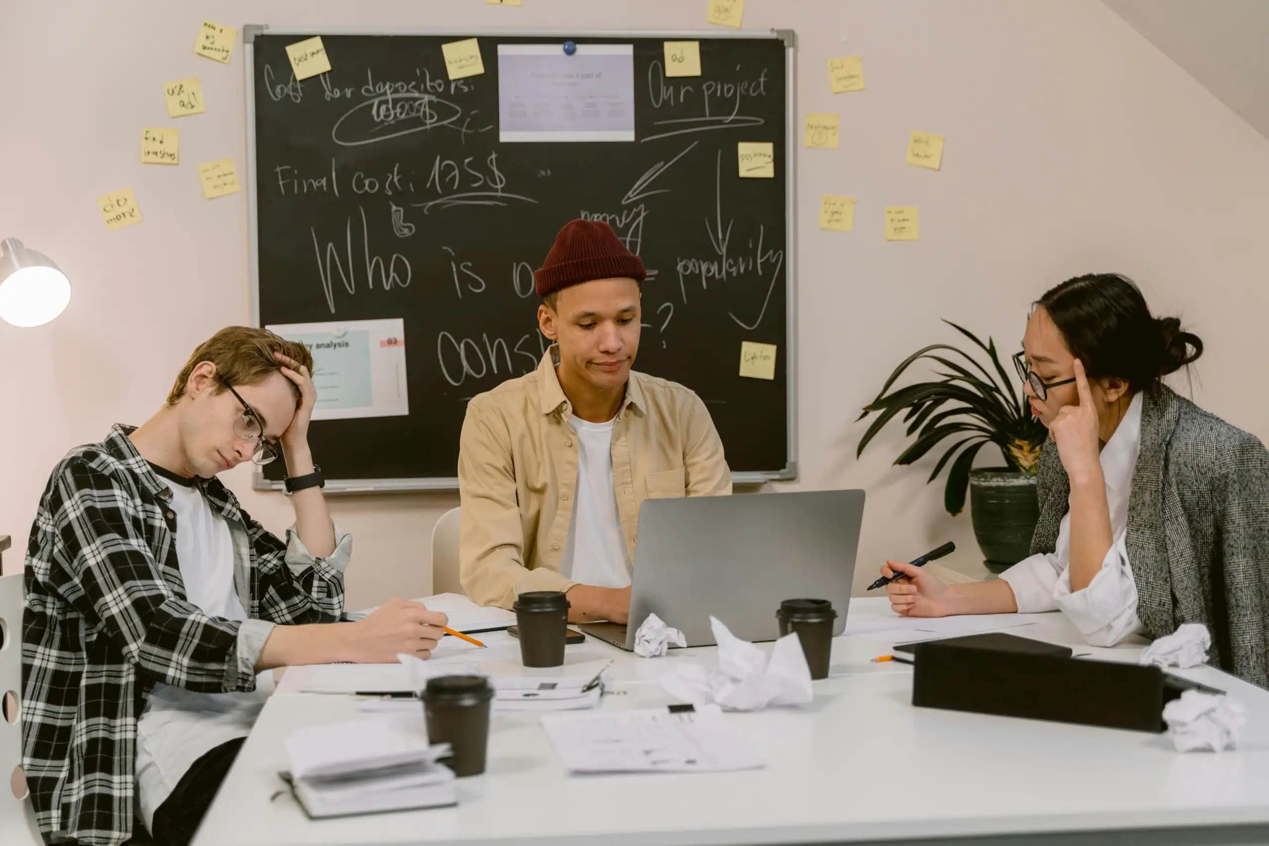 Group of students working together showing signs of stress and frustration